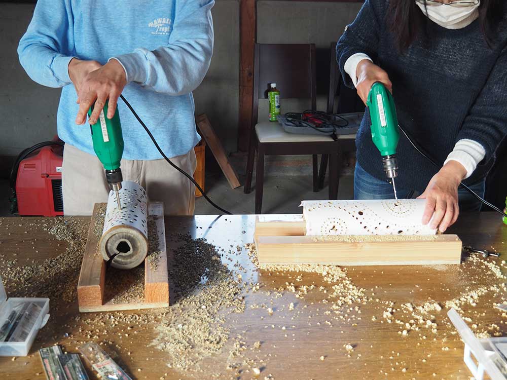 Woemen working drilling holes on bamboo